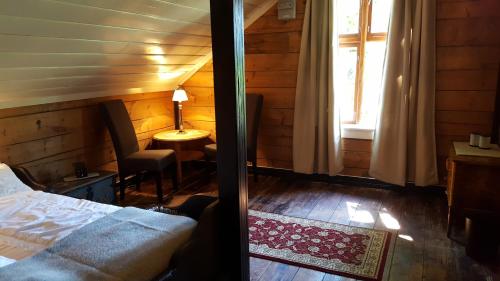 a bedroom with a bed and a desk and a window at Rødseter Gjestegård in Fjarland