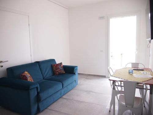 a blue couch in a living room with a table at Hotel Vienna in Pesaro