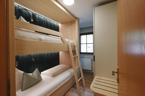 a bunk bed with a ladder in a room at Alpenschlössl Boutique Appartements & Rooms in Neustift im Stubaital