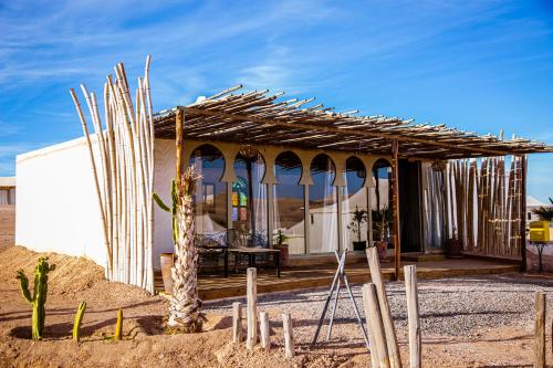 a building in the middle of the desert with a roof at Agafay Yes We Camps & Spa in El Karia