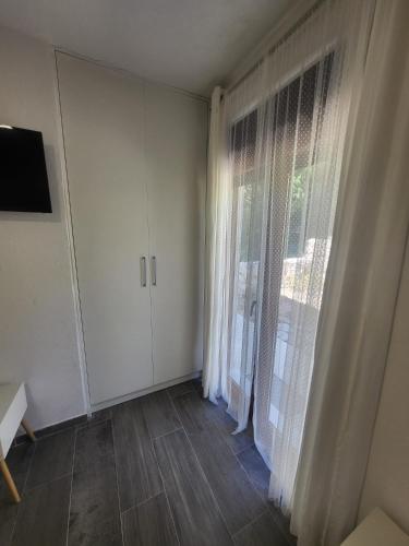 an empty room with a large window with white curtains at Villa Dragi in Klek