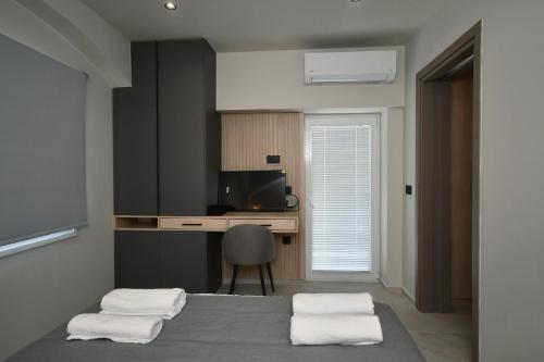 Un dormitorio con una cama, un escritorio y una silla. en Holi Top Luxurious Apartment, en Ierápetra