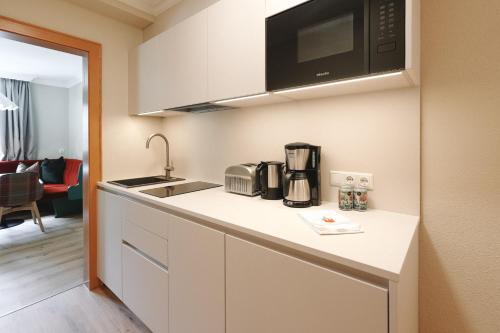 a small kitchen with a sink and a microwave at Alpenschlössl Boutique Appartements & Rooms in Neustift im Stubaital