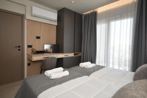 Un dormitorio con una cama grande con dos toallas. en Holi Top Luxurious Apartment, en Ierápetra