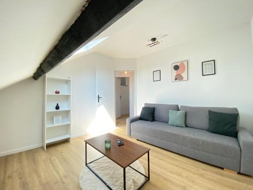 un salon avec un canapé et une table dans l'établissement Appt 4 couchages Jardin Laverie Parking, à Dunkerque