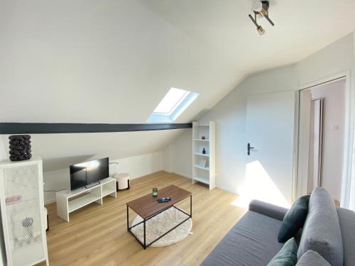 un salon avec un canapé et une télévision dans l'établissement Appt 4 couchages Jardin Laverie Parking, à Dunkerque