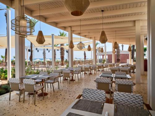a restaurant with tables and chairs and lights at Paloma Grida in Belek
