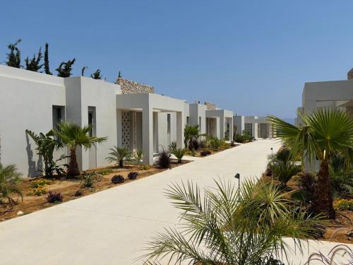a row of white houses with palm trees at THEODOROU villas in Kos Town