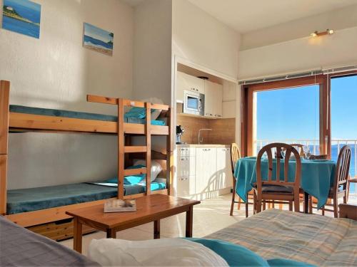 - une chambre avec des lits superposés et une salle à manger avec une table dans l'établissement Studio lumineux 4 couchages près de la plage avec options linge et Wifi - FR-1-251-433, au Lavandou