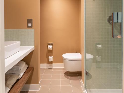 a bathroom with a toilet and a glass shower at Numa Brighton Pavilion in Brighton & Hove