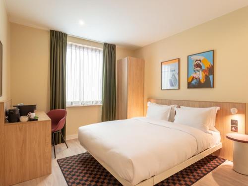 a hotel room with a bed and a desk at Numa Brighton Pavilion in Brighton & Hove
