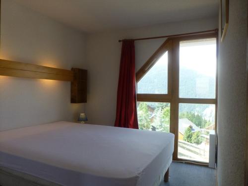 une chambre avec un lit et une grande fenêtre dans l'établissement Duplex 8 pers, skis aux pieds à Vallandry, proche centre, balcon - FR-1-757-128, à Landry