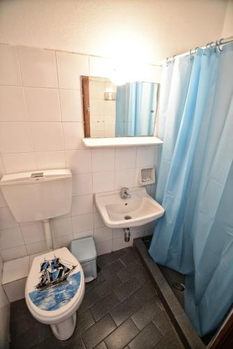 a bathroom with a toilet and a sink and a mirror at To Gefyraki Rooms in Agios Kirykos
