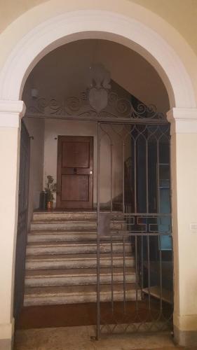 an archway with a staircase in a building at All'ombra della Torre only Rooms in Siena