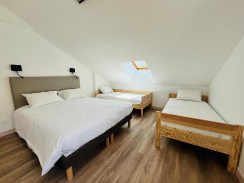 two twin beds in a room with wooden floors at L'écrin du Ferrand in Le Dévoluy