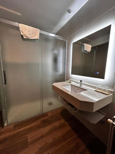 a bathroom with a sink and a shower at Hotel Mirasierra in Coto Ríos