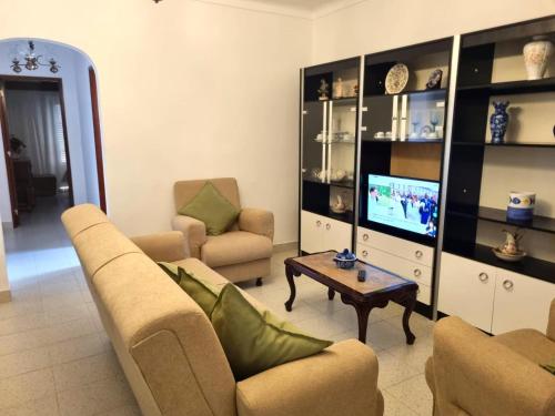a living room with two couches and a tv at CASA DO SOL by Stay in Alentejo in Vila Nova de Milfontes