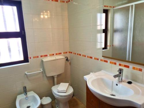 a bathroom with a toilet and a sink at CASA DO SOL by Stay in Alentejo in Vila Nova de Milfontes
