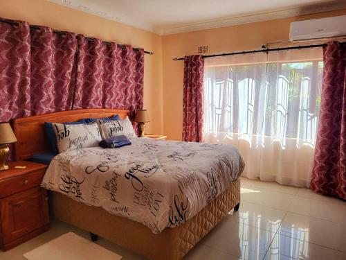 un dormitorio con una cama y una ventana en BRT Apartments, en Livingstone