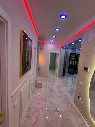 a hallway with a marble floor and red lights at Vila luxury chiajna in Chiajna