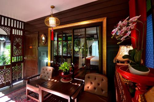 a room with a table and chairs and a bedroom at Thai Thai Sukhothai Resort in Sukhothai