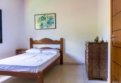 グアペにあるCasa Linda Alecrim do Campo em Capitólio - MGの木製のヘッドボードが付いたベッドのある寝室