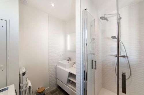 a white bathroom with a shower and a sink at Appartement COCON Balcon et Clim - Lyon Part-Diev - Dreamy Flat Lyon in Lyon