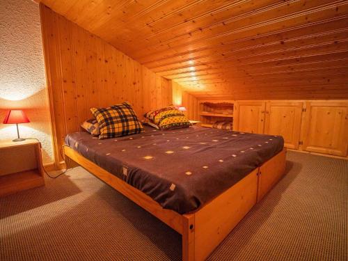 une chambre avec un lit dans une cabane en bois dans l'établissement Charmant 2 pièces mezzanine, skis aux pieds, proche ESF et commerces - Hameau Le Mottet - FR-1-356-188, à Valmorel