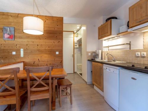 une cuisine avec une table en bois et quelques chaises dans l'établissement Studio cabine 5 personnes avec balcon - La Plagne - FR-1-353-85, à Les Coches
