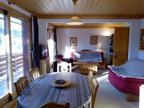un salon avec une table et une chambre dans l'établissement Vaste Appt 2 ch + cabine, 200m des pistes, parking, balcon sud, non-fumeur - FR-1-355-183, à Méribel