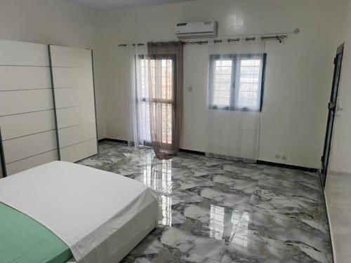 a bedroom with a bed and a marble floor at Studio meublé Saint Louis Sénégal in Saint-Louis