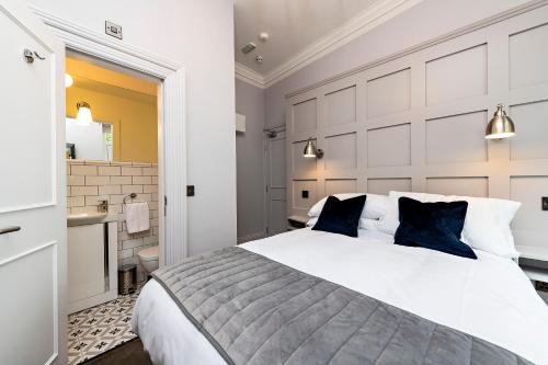 a bedroom with a large white bed and a bathroom at Charming Howth Marina Retreat in Dublin