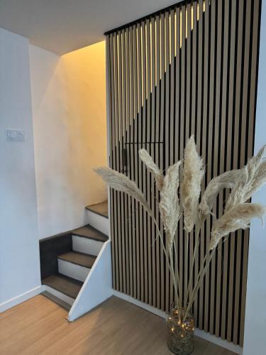 un vase avec une plante dans une pièce avec des escaliers dans l'établissement Chez Marie et Romain Ferry & Shuttle, à Calais