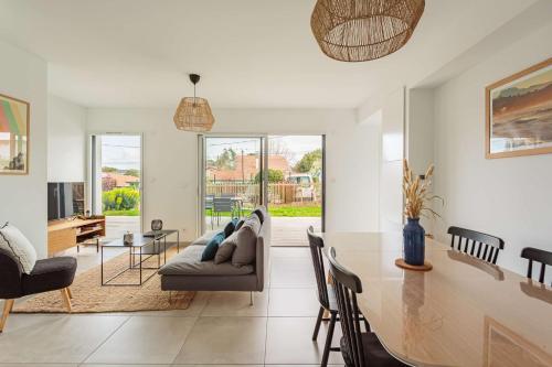 un salon avec un canapé et une table dans l'établissement OLATOU Bel appartement lumineux avec jardin au cœur de Chiberta, à Anglet