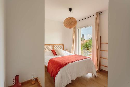 une chambre avec un lit et une grande fenêtre dans l'établissement OLATOU Bel appartement lumineux avec jardin au cœur de Chiberta, à Anglet