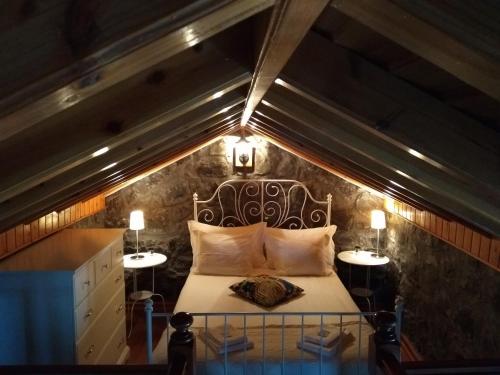 a bedroom with a bed in a attic at Moinho da Cascata in Faja Grande