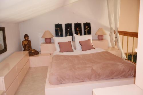 a white bedroom with a large bed and two lamps at Villa les Faou-Anis in Le Castellet