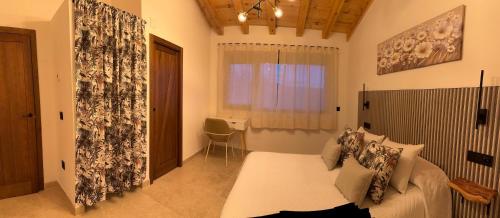 a bedroom with a bed and a window and a table at Casa rural Los Acebos in La Cuesta