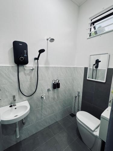 Un baño con ducha, inodoro y lavabo. en Homestay CikguMa 3 - Wi-Fi, en Kota Bharu