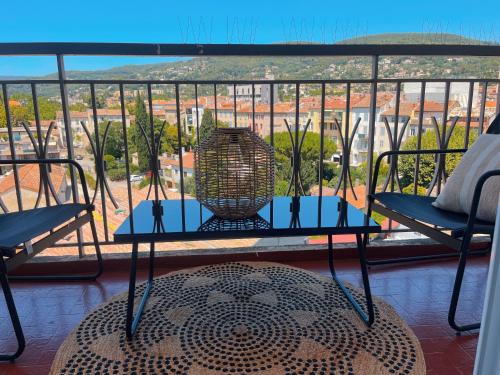 a table and chairs on a balcony with a view at Au 5eme ciel in Draguignan
