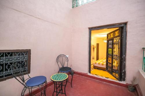 a room with chairs and a table and a window at Riad Dar Jnan Sbil in Fès