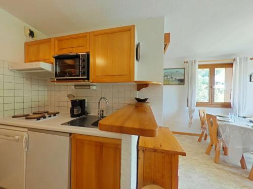 une cuisine avec un évier et un micro-ondes dans l'établissement Appartement 2 Pièces Cabine avec Balcon Sud - Proche Pistes et Commerces - FR-1-241-188, au Grand-Bornand