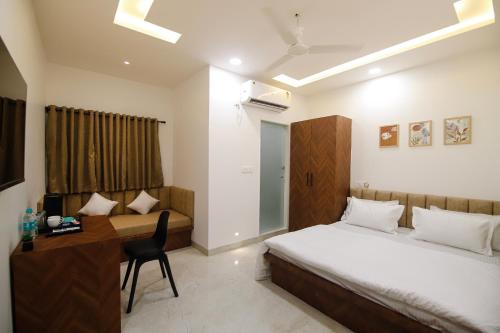 a bedroom with a bed and a desk with a computer at Hotel Super Stay in Ujjain