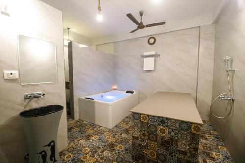 a bathroom with a tub and a sink and a toilet at Hotel Super Stay in Ujjain
