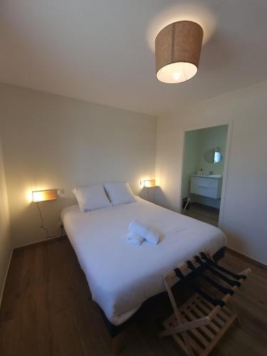 une chambre avec un grand lit blanc avec deux oreillers dans l'établissement Maison proche de la mer, à Pénestin