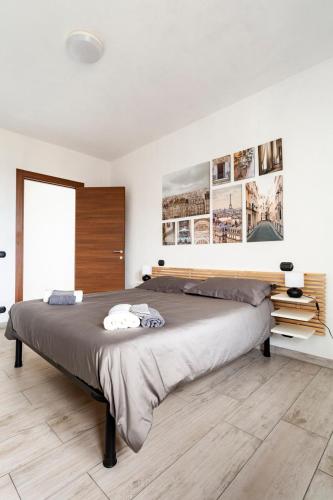 a bedroom with a large bed and pictures on the wall at Villa di Campagna-With WIFI and Private Parking in Pecetto di Valenza