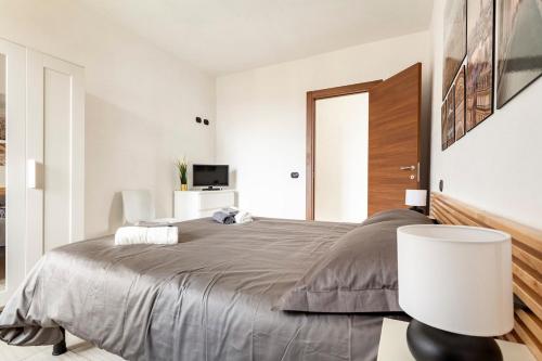 a bedroom with a large bed and a lamp at Villa di Campagna-With WIFI and Private Parking in Pecetto di Valenza