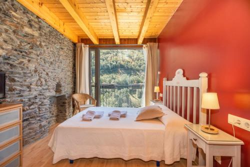 a bedroom with a bed and a large window at Casa Guillem 2 in Tavascan