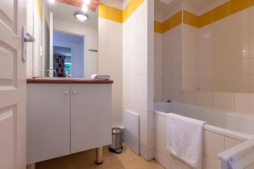 a white bathroom with a tub and a sink at Résidence Odalys Soleil d'Aure in Saint-Lary-Soulan