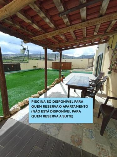 a sign in front of a patio with a table at Alojamento - Apartamento ou quarto - Estacionamento à porta in Arruda dos Vinhos